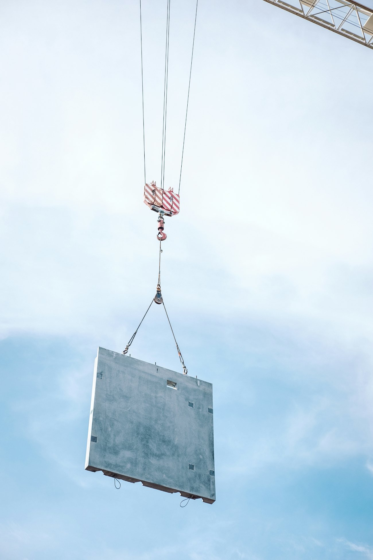 Precast concrete panel lifted into position by a crane on site